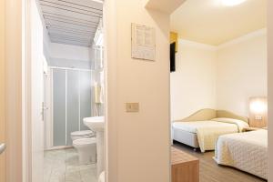 bagno con servizi igienici, letto e lavandino di Hotel Corinna a Rimini