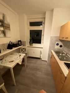 a kitchen with a table and a sink and a window at Apartment Glasower 31 in Berlin