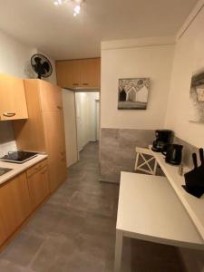 a kitchen with wooden cabinets and a white counter top at Apartment Glasower 31 in Berlin