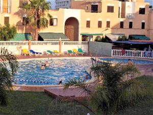 a swimming pool with people in the water at Peniscola Residencial LEK in Peñíscola