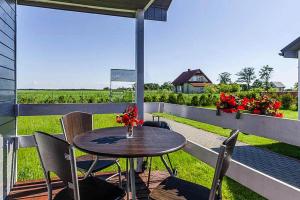 a table and chairs on a patio with a view of a field at Holiday complex, Jezierzany in Jezierzany