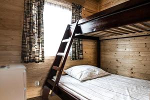 a bunk bed in a wooden room with a window at Holiday complex, Jezierzany in Jezierzany