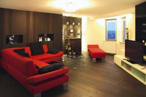 a living room with red furniture and a television at Apartment in the water tower, Güstrow in Güstrow
