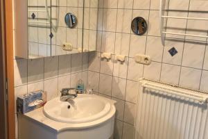 a bathroom with a sink and a toilet and a mirror at Ferienhaus Rhönblick, Kaltensundheim in Kaltensundheim +27 photos
