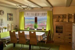 a dining room with a table and chairs and a window at Ferienhaus Rhönblick, Kaltensundheim in Kaltensundheim