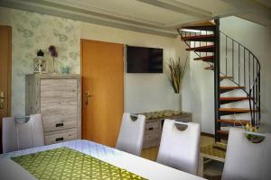 a dining room with a table and chairs and a staircase at Ferienhaus Rhönblick, Kaltensundheim in Kaltensundheim