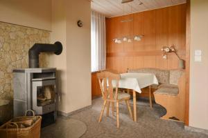 salon ze stołem i piecem opalanym drewnem w obiekcie Holiday Home Nahetal-Waldau - DMG07059-F w mieście Waldau