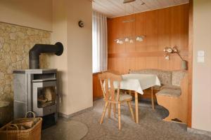 sala de estar con mesa y estufa de leña en Holiday Home Nahetal-Waldau - DMG07059-F, en Waldau