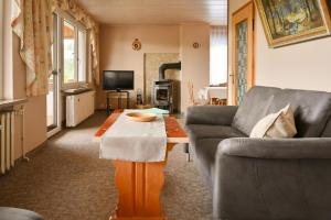 uma sala de estar com um sofá e uma mesa de centro em Holiday Home Nahetal-Waldau - DMG07059-F em Waldau