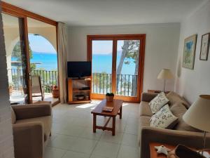 a living room with a couch and a tv at Port Pollensa Pins 2 in Pollença