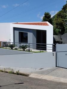 a white house with black windows and a white fence at Anjos's Choice in Ponta do Sol