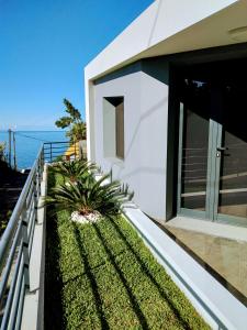 Biały dom z balkonem z widokiem na ocean w obiekcie Anjos's Choice w mieście Ponta do Sol