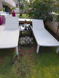 two white benches sitting next to a table at Sunrise Apartment in Souda