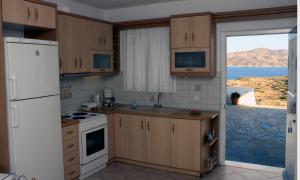 eine Küche mit einem weißen Kühlschrank und einem Fenster in der Unterkunft Anatoli in Kimolos