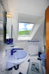 Apartment in Kleines Wiesental, Sallneck في Sallneck: حمام أبيض مع حوض ونافذة