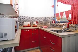 a small kitchen with red cabinets and a microwave at Cottage, Perlin in Perlin