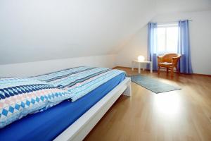 a bedroom with a bed and a chair and a window at Holiday home Barbara, Zarrentin in Zarrentin