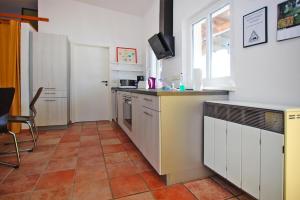 a kitchen with white cabinets and a tile floor at Semi-detached house at Flacher See, Klocksin in Klocksin