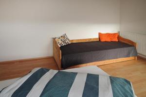 sypialnia z łóżkiem pojedynczym i pomarańczową poduszką w obiekcie Apartment in Meßstetten near Ski Slopes w mieście Meßstetten