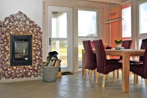 a dining room with a table and a fireplace at Ferienhaus mit Sauna am Dümmer See, Dümmer in Dümmer