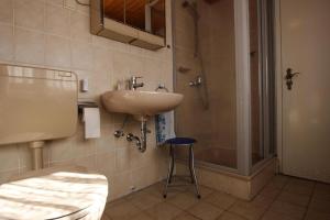 a bathroom with a sink and a shower and a stool at Vacation Rental Cottage, Oybin in Hain