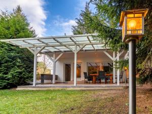a white pergola on a house with a table at Ferienhaus mit Terrasse und Kaminofen in Parchim in Parchim +9 photos