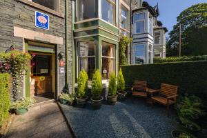 a building with potted plants and a table and chairs at Burnside B&B in Keswick