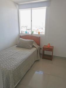 um quarto com uma cama, uma janela e uma mesa em Matiz 01 em Iquique