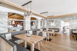un restaurante con mesas y sillas de madera y paredes de ladrillo en Sporthotel Olymp en Hochgurgl
