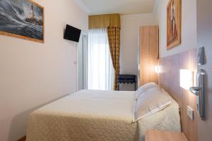 una camera d'albergo con un letto in una stanza di Hotel Corinna a Rimini