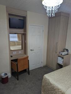 a bedroom with a bed and a mirror and a chandelier at The Stafford in Blackpool