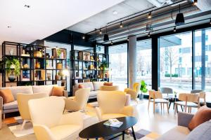 un vestíbulo con sofás, mesas y sillas en Staycity Aparthotels Frankfurt Airport, en Frankfurt
