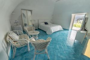 a bedroom with a bed and a table and chairs at Postcard House in Vico Equense