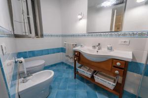 a bathroom with a sink and a toilet and a mirror at Postcard House in Vico Equense +39 photos