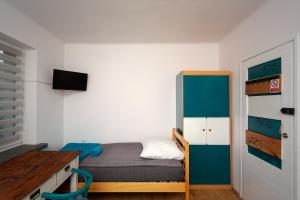niewielka sypialnia z łóżkiem i biurkiem w obiekcie APARTAMENT 16 w mieście Zamość