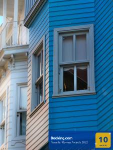 um edifício com revestimento azul e janelas em Tilas - Rooms in 19th Century Wooden Townhouse,Kadikoy em Istambul