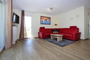 uma sala de estar com um sofá vermelho e uma mesa em Appartement Hafenflair am Plauer See, Plau am See em Plau am See