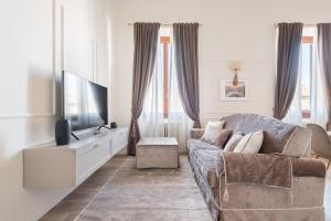 ein Wohnzimmer mit einem Sofa und einem TV in der Unterkunft Florence Feel Apartment in Florenz