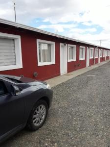 une voiture garée devant une rangée de bâtiments dans l'établissement AYRES DEL SUR Patagonia, à Río Gallegos