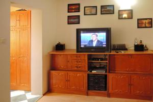 a television sitting on top of a wooden entertainment center at Terraced house, Rewal in Rewal