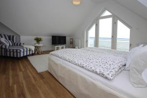 a white bedroom with a large bed and a window at Apartment Seeblick, Plau am See in Plau am See