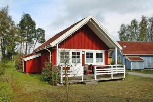 a red and white house with a white fence at Holiday house at the Useriner See, Userin in Userin