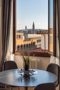 a table and chairs in a room with a large window at Florence Feel Apartment in Florence