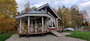 una pequeña casa con porche y escaleras en un campo en Uusi Saunamökki Jämsässä, lähellä Himosta, en Jämsä