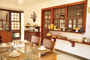 a room with a table and chairs and shelves with food at Casa Aldeia Paraty in Paraty