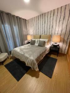 - une chambre avec un lit avec deux lampes et deux tables dans l'établissement Apartamentos da Sé Catedral, à Funchal
