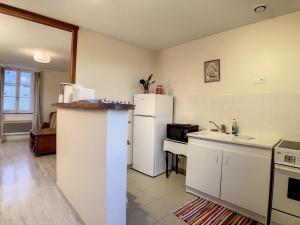 uma cozinha com um frigorífico branco e um lavatório em Boutons d'or em Tierceville