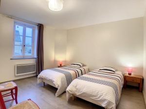 two beds in a room with a window at Boutons d'or in Tierceville