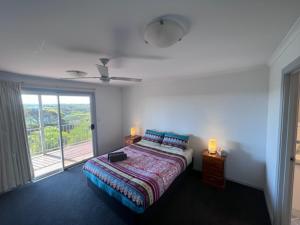 a bedroom with a bed and a large window at Vivonne Bay Island Getaway in Vivonne Bay