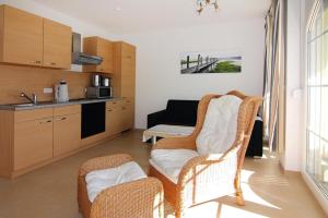 a living room with two chairs and a kitchen at Apartment, Graal-Müritz in Graal-Müritz